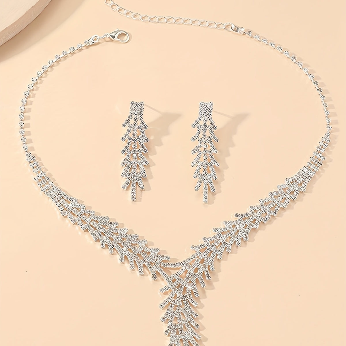 Aveline silver-tone crystal necklace and fringe drop earrings laid flat
