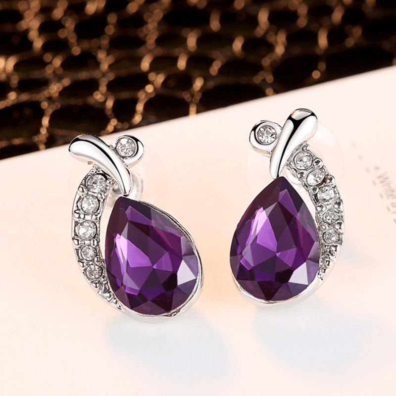Close-up of the Sirène violet teardrop stud earrings with crystal accents