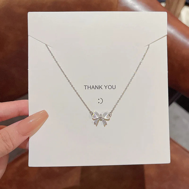Opaline Bow necklace: small bow pendant on a fine chain, on a gift card