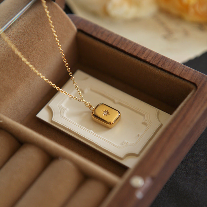 Sunward gold-tone square locket necklace with a small star stone, in a jewellery box