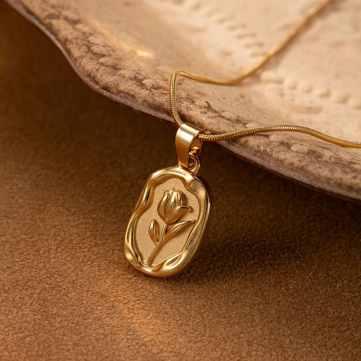 Golden Tulip gold-tone oval medallion necklace with an embossed tulip