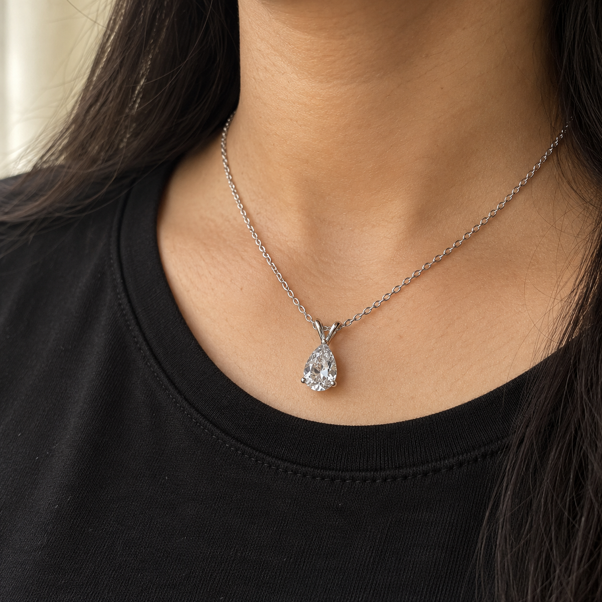 Clear pear-cut pendant on a fine silver-tone chain – worn with a black crew-neck top