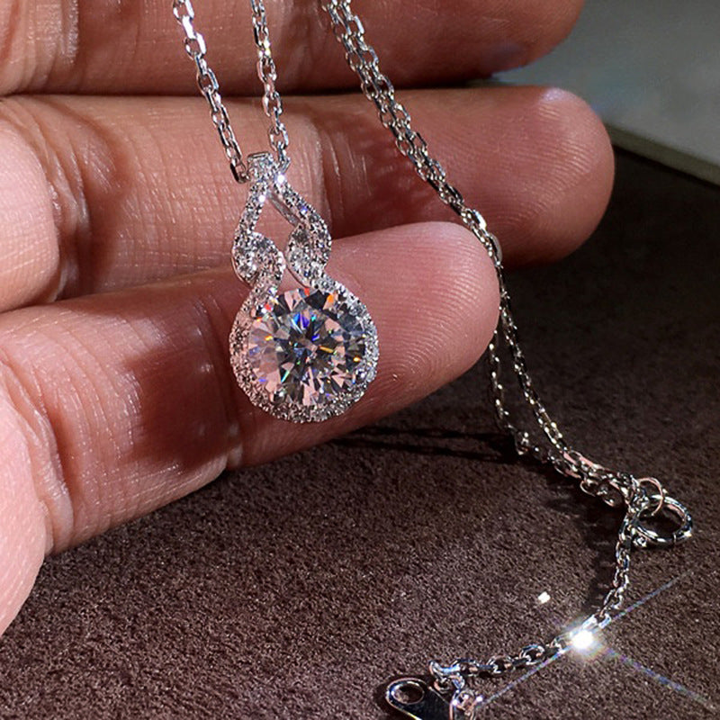 Éclat halo pendant in hand on a dark background