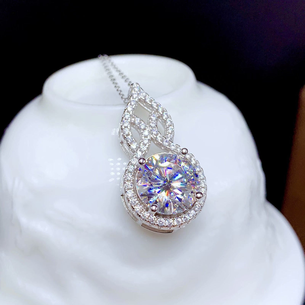 Éclat solitaire pendant close-up on a white stand