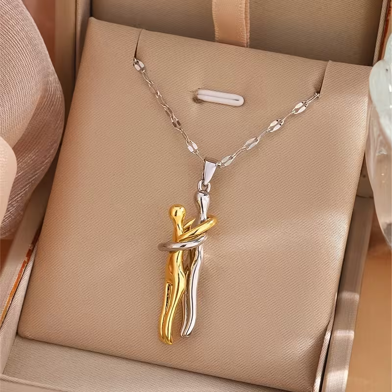 The Embrace pendant: two-tone embracing couple figure on a silver-tone chain