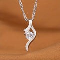 Ondine pendant: round clear zirconia cradled in an open silver-tone ribbon