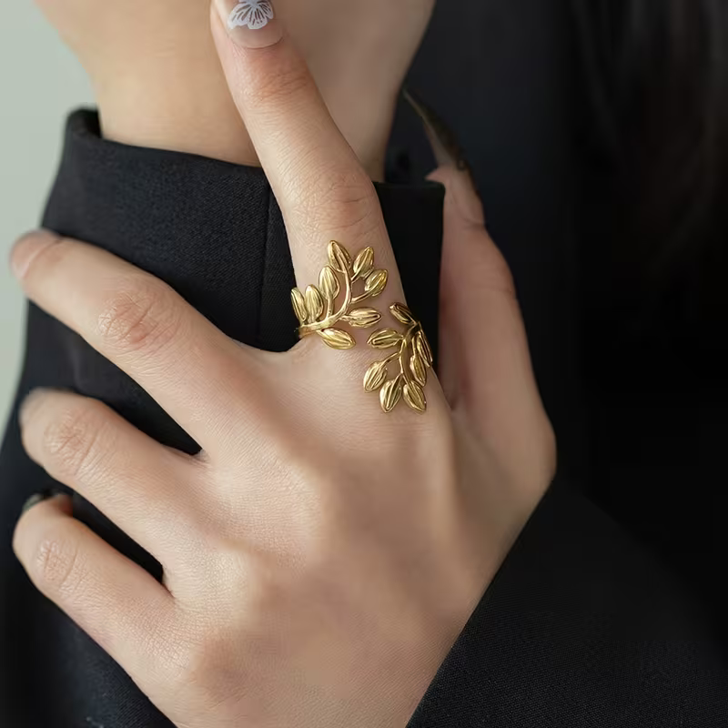 Gilded Leaf gold-tone adjustable wrap ring with leaves, worn on the finger