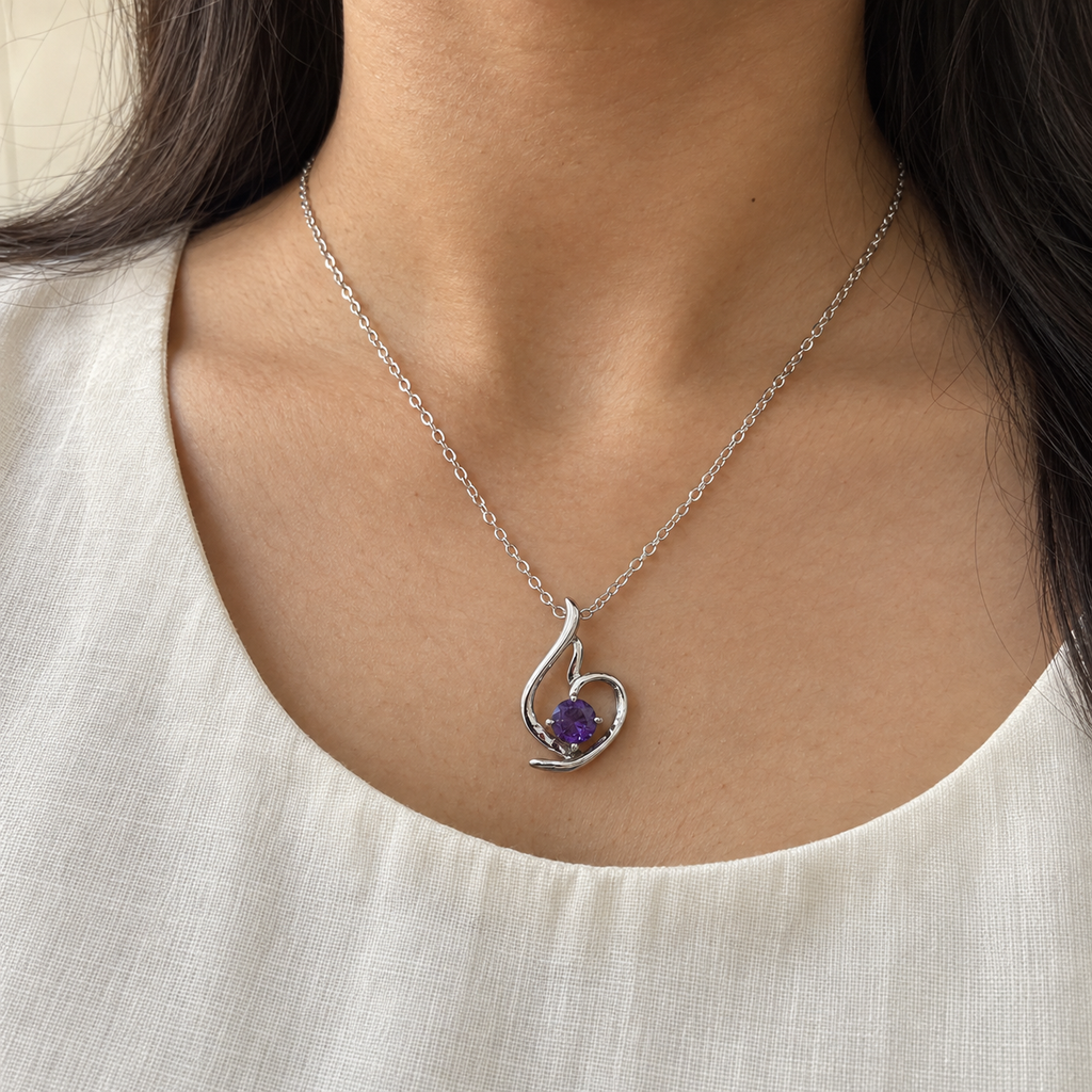 Lumière silver-tone heart pendant with a round violet stone – worn with an ivory kurta, collarbone view