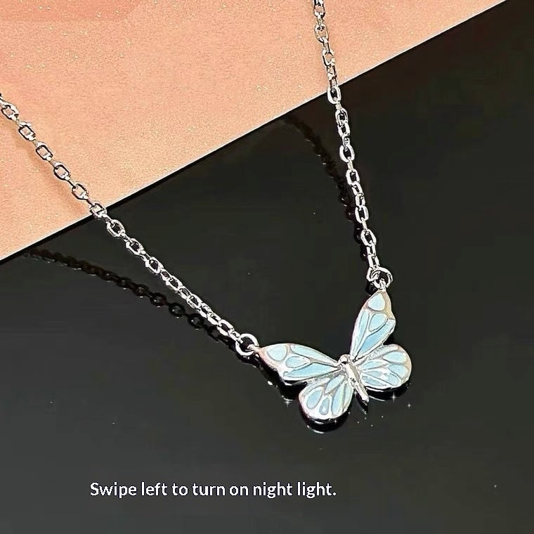 Luminous butterfly necklace in daylight: silver-tone chain with enamel wings