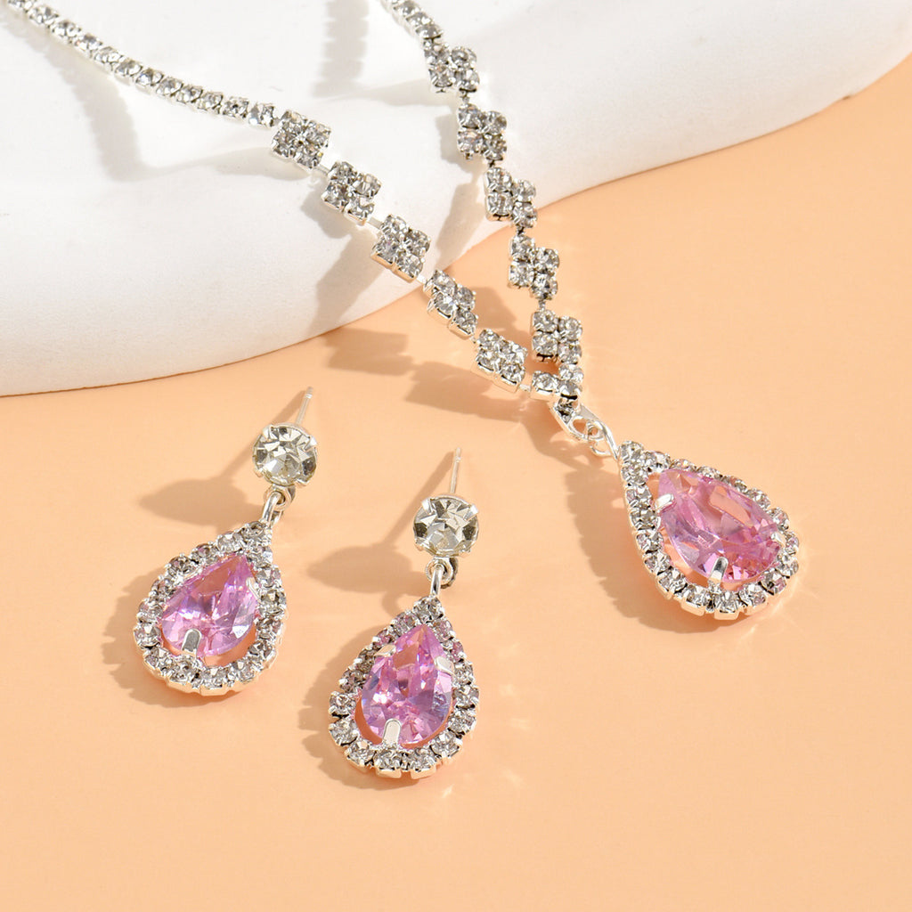 Pink Soirée teardrop necklace and halo drop earrings laid flat